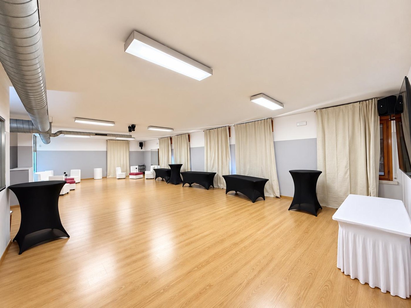 Sala Luna at FLAC Concorezzo: open space with exposed ceiling, parquet and high tables